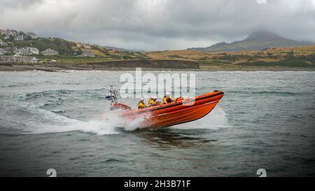 RNLI Criccieth Lifeboat Station's Atlantic 85 class scialuppa di salvataggio che alimenta attraverso le onde. Foto Stock