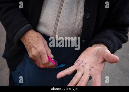 Primo piano delle mani di una donna anziana con numeri scritti su di esse Foto Stock