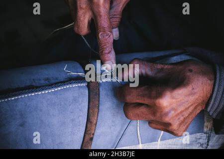 Primo piano di un vecchio cucito delle mani Foto Stock