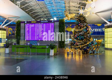 Ucraina, Kiev - 29 dicembre 2020: Banco check-in vuoto per un volo per l'aeroporto. Natale. Decorazioni per l'anno nuovo all'aeroporto di Boryspil. Ghirlande e luci, inverno in vacanza. Foto Stock