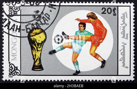 MONGOLIA - CIRCA 1990: Un francobollo stampato in Mongolia mostra i giocatori di calcio in azione, 1990 Mondiali di Calcio, Italia, circa 1990 Foto Stock