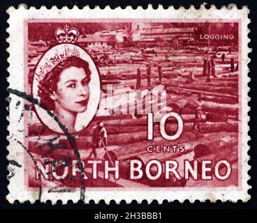 NORTH BORNEO - CIRCA 1954: Un francobollo stampato in Malesia mostra logging, Regina Elisabetta II, ritratto, circa 1954 Foto Stock