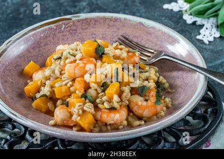 Risotto di orzo perlato con gamberi re, zucca di butternut e salvia Foto Stock