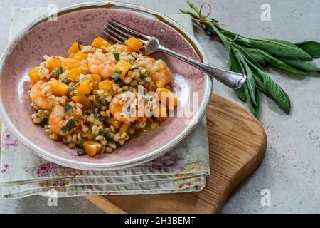 Risotto di orzo perlato con gamberi re, zucca di butternut e salvia Foto Stock