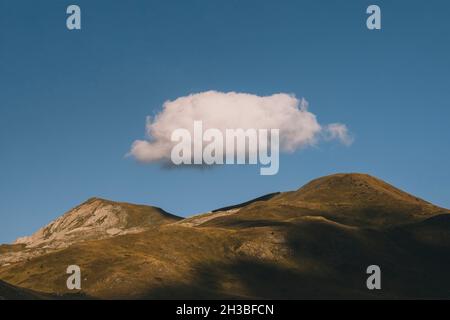 Grande nube sulla cima delle cime di montagna durante il tramonto, Pirenei Foto Stock