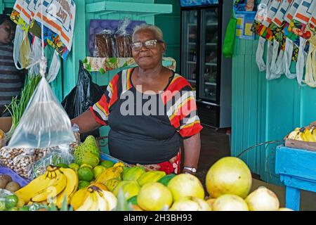 Donna nera che vende frutta in negozio nella capitale Port Elizabeth sull'isola di Bequia, parte della nazione Saint Vincent e Grenadine, Caraibi Foto Stock