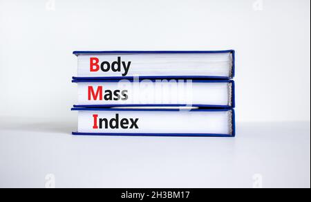 Simbolo indice di massa corporea BMI. Parole di concetto 'indice di massa corporea BMI' su libri su un bel tavolo bianco, sfondo bianco. Stile di vita sano e corpo BMI Foto Stock