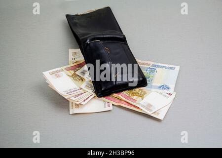 Portafoglio retro-nero e banconote di 1000 e 100 rubli che sporgono da esso. Business e finanza, il concetto di ricchezza. Crisi. Foto Stock