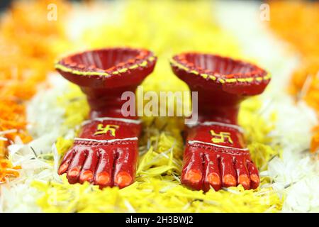 Piedi della dea indù Lakshmi chiamato Laxmi Charan con Diya, profondo o dia su Rangoli fiore di Marigold. Tema per Shubh Deepawali e Laxmi Pooja Foto Stock