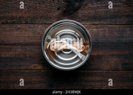 Osso del cane in ciotola su sfondo di legno. Ossa artificiali per animali domestici. Osso di cane a lunga durata Foto Stock