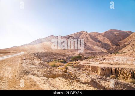 Montagne rocciose e polverose del deserto del Negev in Israele. Sunbeam, luce del sole sulla montagna. Foto Stock