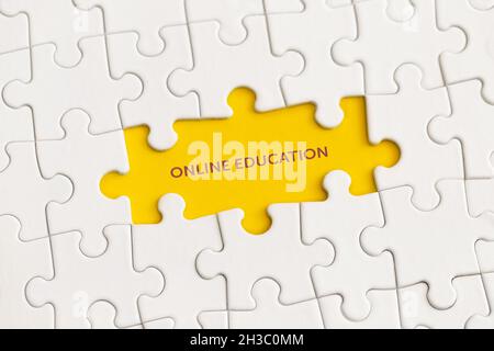 Dettagli bianchi del puzzle con il testo "Online Education" su sfondo giallo. Foto Stock