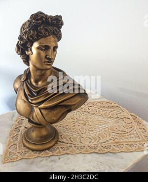 SYDNEY, AUSTRALIA - Sep 16, 2021: Una vita morta: Oro bronzato antico busto romano su tessuto di pizzo Foto Stock