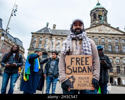 Amsterdam, Paesi Bassi. 27 ottobre 2021. Un uomo sudanese ha visto tenere un cartello che dice "Free Sudan'during the dimostration. I sudanesi residenti nei Paesi Bassi si sono riuniti in Piazza Dam, nel centro di Amsterdam, per protestare contro il colpo di stato militare in Sudan. Lunedì il leader del colpo di stato Gen Abdel Fattah Burhan sciolse il governo civile, arrestò i leader politici e chiamò lo stato di emergenza. Un gran numero di manifestanti si trova nelle strade della capitale che chiede il ritorno del dominio civile. (Foto di Ana Fernandez/SOPA Images/Sipa USA) Credit: Sipa USA/Alamy Live News Foto Stock