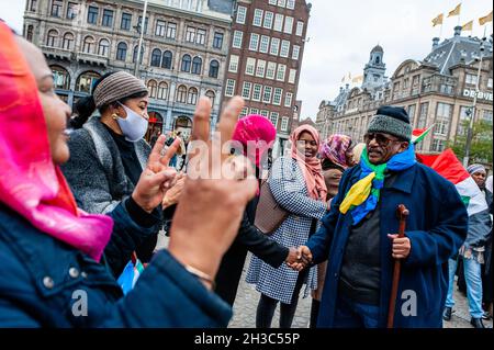 Amsterdam, Paesi Bassi. 27 ottobre 2021. Durante la manifestazione un uomo sudanese si è rallegrato di un gruppo di donne sudanesi. I sudanesi residenti nei Paesi Bassi si sono riuniti in Piazza Dam nel centro di Amsterdam per protestare contro il colpo di stato militare in Sudan. Lunedì il leader del colpo di stato Gen Abdel Fattah Burhan sciolse il governo civile, arrestò i leader politici e chiamò lo stato di emergenza. Un gran numero di manifestanti si trova nelle strade della capitale che chiede il ritorno del dominio civile. (Foto di Ana Fernandez/SOPA Images/Sipa USA) Credit: Sipa USA/Alamy Live News Foto Stock