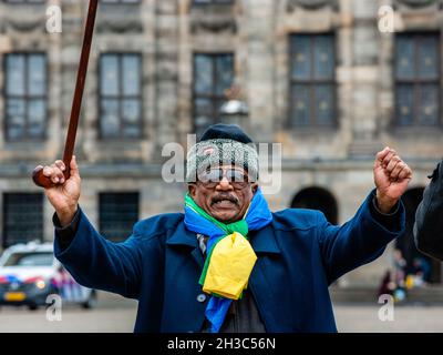 Amsterdam, Paesi Bassi. 27 ottobre 2021. Un uomo sudanese tiene un bastone durante la dimostrazione.i sudanesi che vivono nei Paesi Bassi si sono riuniti in Piazza Dam nel centro della città di Amsterdam per protestare contro il colpo di stato militare in Sudan. Lunedì il leader del colpo di stato Gen Abdel Fattah Burhan sciolse il governo civile, arrestò i leader politici e chiamò lo stato di emergenza. Un gran numero di manifestanti si trova nelle strade della capitale che chiede il ritorno del dominio civile. (Foto di Ana Fernandez/SOPA Images/Sipa USA) Credit: Sipa USA/Alamy Live News Foto Stock