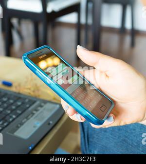 POZNAN, POLONIA - 12 ottobre 2016: Una donna che digita con il suo smartphone su un messaggero in una stanza Foto Stock