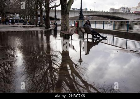 Londra, Regno Unito - 20 novembre 2020, i giovani sono seduti su una panchina, guardando il Tamigi. Riva sud Foto Stock