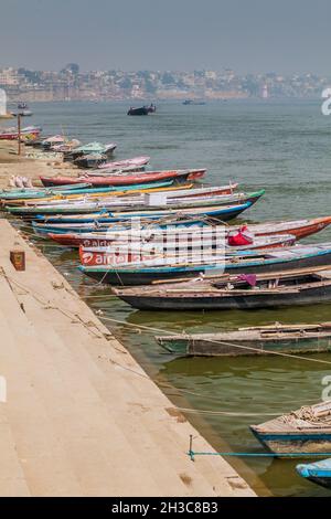 VARANASI, INDIA - 25 OTTOBRE 2016: Piccole barche vicino Ghats scalini che conducono alle rive del fiume Ganges in Varanasi, India Foto Stock