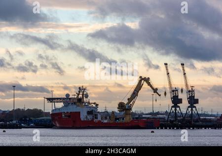 tramonto su marchwood porto militare e gru sul bordo del porto di southampton banchine, uk. dockyard gru, flotta reale navi ausiliarie, esercito. Foto Stock