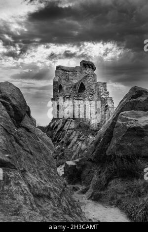 Foto in scala di grigi del castello di Mow Cop sotto un cielo nuvoloso in Inghilterra, nel Regno Unito Foto Stock