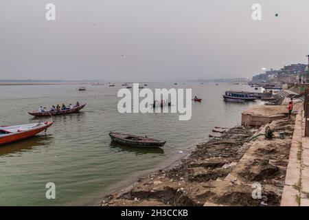 VARANASI, INDIA - 25 OTTOBRE 2016: Piccole barche vicino Ghats scalini che conducono alle rive del fiume Ganges in Varanasi, India Foto Stock