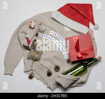 Cappello Santa rosso con scatola di cervi giocattolo in maglia con regalo e bottiglia verde Foto Stock