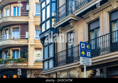 PORTUGALETE, SPAGNA - 7 LUGLIO 2021: Cartello informativo per i pellegrini sulla Via San Giacomo e facciate colorate nella città vecchia di Portugalete, Basco Cou Foto Stock