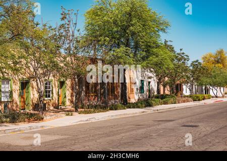 Gli alberi riparano le case di adobe dal sole che splana nel quartiere Barrio Viejo di Tucson, Arizona Foto Stock