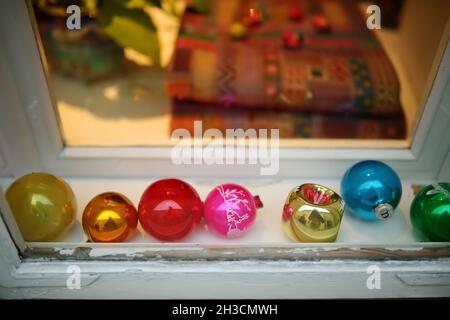 Finestra decorata da una varietà di baubles vintage retrò Natale. Decorazioni natalizie insolite. Foto Stock