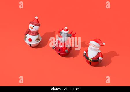 Сomposition di giocattoli di Natale su sfondo rosso con ombre dure Foto Stock