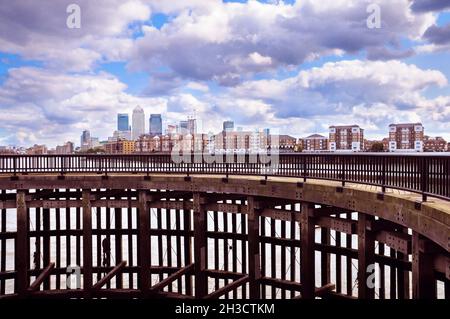 Vista dal bacino di Shadwell nel Tower Hamlets di Londra attraverso il Tamigi, fino agli appartamenti lungo il fiume e allo skyline di Canary Wharf. East London, Inghilterra, Regno Unito Foto Stock