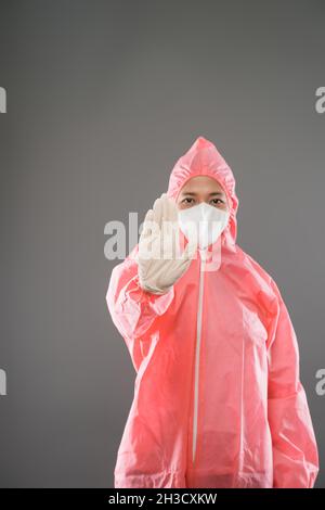 Gli operatori sanitari indossano dispositivi di protezione personale con i palmi in avanti come gesto di arresto Foto Stock