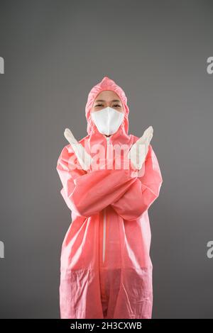 Gli operatori sanitari indossano dispositivi di protezione individuale con due palmi in avanti come gesto di arresto Foto Stock