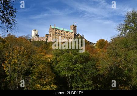 25 ottobre 2021, Turingia, Eisenach: Gli alberi sotto il Castello di Wartburg stanno girando colori autunnali. La Turingia commemora la traduzione della Bibbia da parte del riformatore della chiesa Martin Lutero 500 anni fa con un anno di festeggiamenti. Il focus è su Eisenach, dove Lutero gettò le basi per una lingua tedesca scritta standardizzata con la sua traduzione biblica al Castello di Wartburg nel 1521/22. Numerosi eventi sono previsti sotto il motto "tradurre il mondo". Il 31 ottobre, giorno della riforma, l'anno del festival sarà ufficialmente aperto. (A dpa 'Bibbia traduzione 500 anni fa - Turingia volto Foto Stock