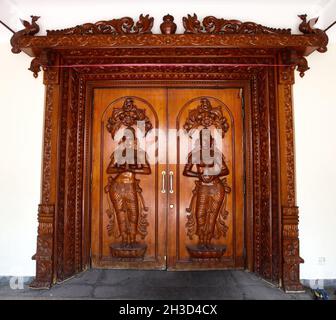 Porta d'ingresso in legno intagliato decorativo sulla strada Pagoda per il Tempio di Sri Mariamman a Chinatown di Singapore. Foto Stock