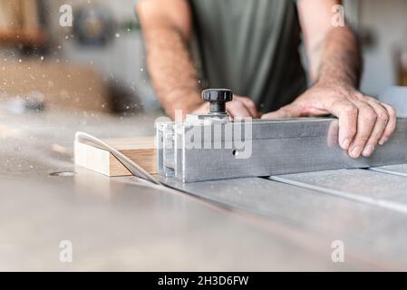 Persona che taglia un gradino diagonalmente sulla tavola scorrevole Foto Stock