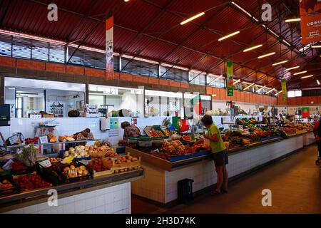 Shoppers guardando i prodotti freschi per la vendita nel mercato coperto, Olhau, Algarve, Portogallo, dell'Europa. Foto Stock