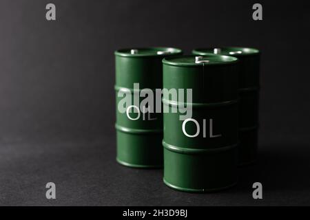 barili di latta di olio verde su sfondo nero Foto Stock