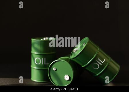 barili di latta di olio verde su sfondo nero Foto Stock