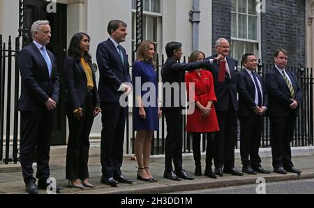 Londra, Inghilterra, Regno Unito. 27 ottobre 2021. Il Cancelliere dello scacchiere, RISHI SUNAK (C) detiene la scatola del bilancio nella sua forma attuale con i membri del suo team del Tesoro, tra cui ROB BUTLER MP (L), Segretario privato parlamentare al Tesoro CLAIRE COUTINHO (2°, L), Segretario economico al Tesoro JOHN GLEN (3°, L), Segretario finanziario al Tesoro LUCY FRAZER (4th L), Segretario dello scacchiere al Tesoro HELEN WHATELY (4th, R), Ministro di Stato Lord AGNEW (3rd, R), Signore Commissario del Tesoro ALAN MAK (2nd, R) e Segretario privato parlamentare al Capo Segretario CRAIG WIL Foto Stock