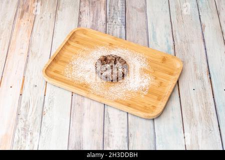 Biscotti al cioccolato fondente con zucchero a velo su un vassoio di bambù Foto Stock