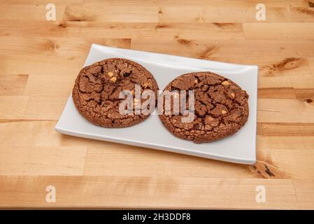 Biscotti all'americana ripieni di cioccolato e nocciole su piatto bianco Foto Stock