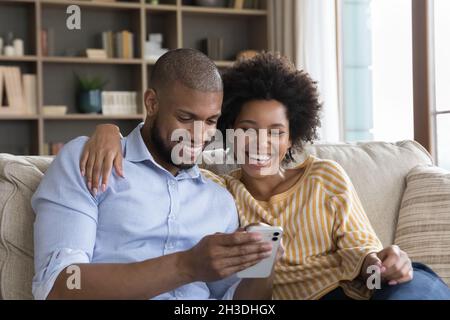 Felice bella coppia afroamericana giovane usando il cellulare. Foto Stock