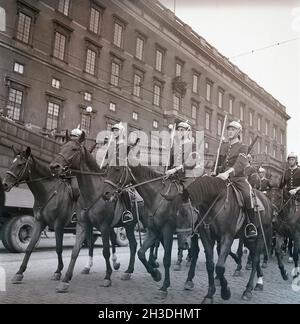 soldati degli anni '40 sui cavalli. Nella strada con il castello reale di Stoccolma sullo sfondo, i soldati stanno cavalcando per la cerimonia del cambio delle guardie. Rif. Kristoffersson AD32-8. 1947. Foto Stock