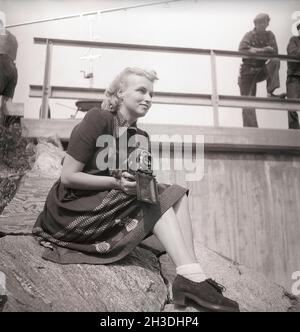 Fotografo negli anni '40. Una giovane donna fotografa in una giornata estiva. La telecamera è un Rolleiflex della società tedesca Rollei per film da 60 mm. Svezia 1946. Foto Kristoffersson Rif V70-5 Foto Stock