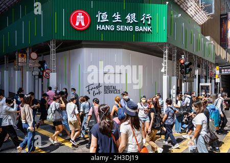 Hong Kong, Cina. 06 ottobre 2021. I pedoni sono visibili attraversando la strada di fronte alla filiale della Hang Seng Bank a Hong Kong. (Foto di Budrul Chukrut/SOPA Images/Sipa USA) Credit: Sipa USA/Alamy Live News Foto Stock