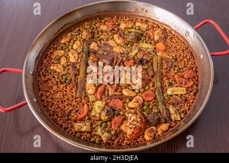 Paella vegetale con socarrat, asparagi selvatici, cavolfiore, fagioli verdi, caraffa e carote Foto Stock