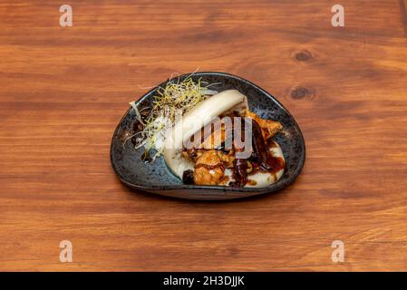 Delizioso panino asiatico bao con pollo e stufato di funghi con salsa teriyaki e germogli di fagioli Foto Stock