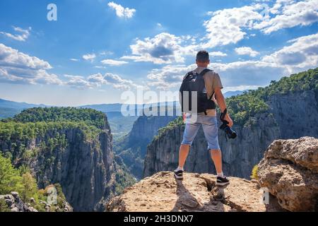 Uomo senza volto con fotocamera sulla scogliera Foto Stock